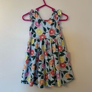 Hanna Andersson citrus cotton dress with pockets and ruffle sleeve details.